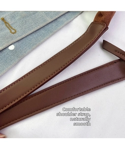 Close-up of durable brown leather shoulder strap with meticulous double stitching detail