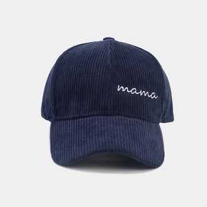 Detail of white mama embroidery on navy blue corduroy baseball cap with textured fabric