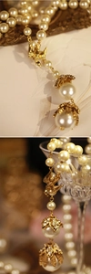 Dettaglio della collana di perle con pendente a uccello e fiori di strass luccicanti