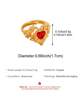 Detail view of gold heart ring with red gemstone and etched leaf patterns on copper band
