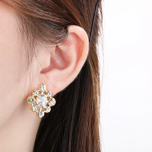 Close-up of elegant gold stainless steel stud earrings with white zircon on ear lobe