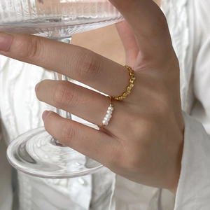 French style gold ring set with pearls and geometric texture worn on hand