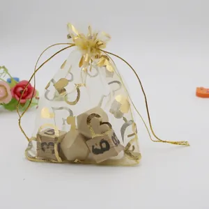 Detail of organza drawstring bag featuring gold foil heart patterns and silk ribbon