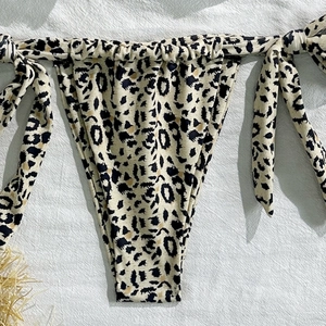 Detail view of leopard print bikini bottom with side ties and ruched fabric design
