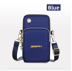 Detail of blue nylon crossbody bag with gold zippers and flower pendant accessory