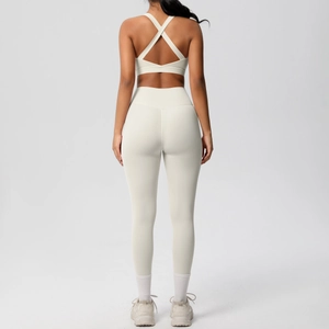 Vista trasera de un conjunto de yoga blanco crema con sujetador cruzado y leggings de cintura alta