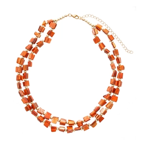 Double-layer necklace with irregular orange beads and gold-tone spacers on white background