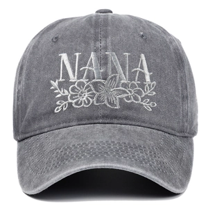 Detailed close-up of white Nana floral embroidery on washed gray cotton baseball cap