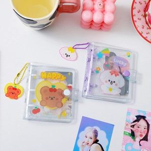 Detail of 3-ring binder photo albums featuring cartoon bear and dog patterns with charms