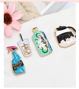 Creative enamel pins featuring coffee pot and bottle ship set on textured fabric