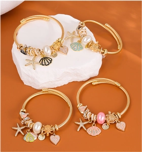 Detail of 4-piece golden ocean-themed bracelets with starfish, shells and pearls