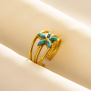 Macro detail of triple-layered gold stainless steel ring with turquoise flower gemstone