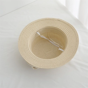 Détail d'un chapeau de paille pour enfant montrant le tissage et la jugulaire élastique