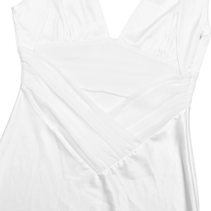 Detailed view of the deep V-neckline and elegant pleated satin fabric on white dress