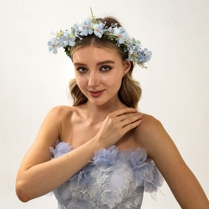 Detail of blue and white artificial floral headband worn by model with matching dress