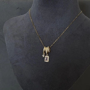 Collier à pampilles doré avec pendentif carré en zircon et cercles sertis sur socle gris
