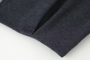 Makroaufnahme der dunkelgrauen Twill-Stoffstruktur und Reißverschluss-Details am Set