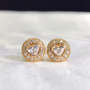 Close-up of heart-shaped halo stud earrings with gold plating and sparkling zircon stones