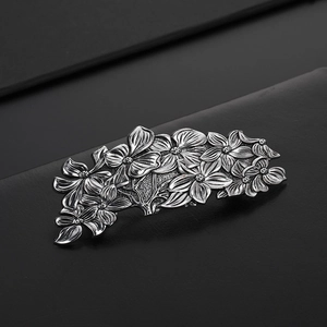 Macro shot of vintage metal flower hair clip with silver embossed floral texture