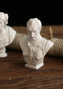 Classic Greek resin busts with fine facial details on a vintage wooden tabletop backdrop