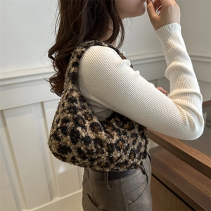 Fashionable leopard print plush hobo bag worn by a model in a bright indoor setting