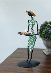 Détail d'un bougeoir créatif en fer présentant une figurine féminine en robe à fleurs