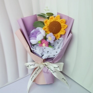 Detail of hand-knitted sunflower and purple rose bouquet with Just for you ribbon