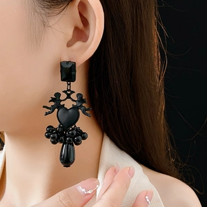 Close-up of Gothic black angel heart earrings with elegant beaded tassels on a model