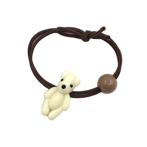 Close-up of brown elastic scrunchie with cute cream bear and coffee-colored bead detail