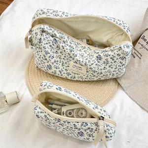 Close-up of quilted floral makeup bag set with blue begonia pattern on white fabric