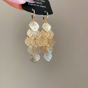 Detailed view of layered geometric fringe earrings with bimetal mesh diamond shapes
