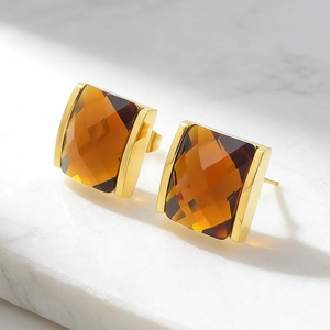 Macro shot of 18K gold plated square stud earrings with amber faceted crystal detail