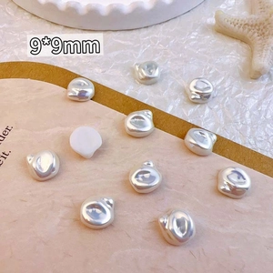 Macro shot of 9x9mm silver heart-shaped and irregular baroque-style nail art charms