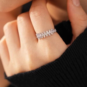 Macro detail of open ring featuring rectangular zircon flower arrangement on hand