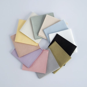 Flat lay of colorful velvet jewelry pouches in pink, blue, beige, and olive green
