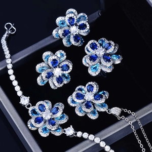 Close-up of elegant blue and white zircon flower jewelry set in a luxury black gift box