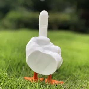 Detailed view of middle finger duck statue with orange feet on green grass
