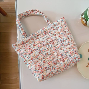 Close-up of quilted floral cotton handbag with diamond stitching and simple wish label