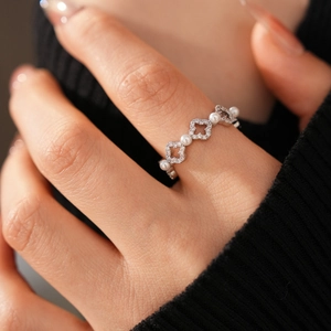 Détail de la bague trèfle évidée avec perles blanches et pierres de zircone cubiques