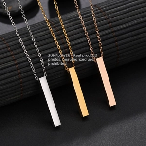 Macro view of three polished vertical bar pendants in silver, gold and rose gold