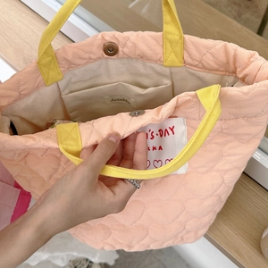 Vue intérieure du sac matelassé rose avec anses jaunes et doublure en toile