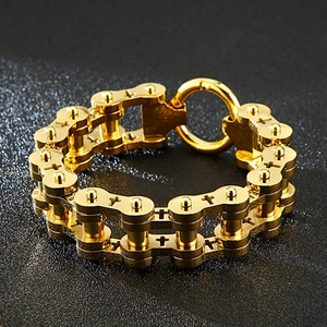 Detailed shot of golden punk bicycle chain bracelet with engraved crosses and O-ring clasp