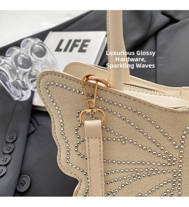 Detail of cream woven tote bag featuring butterfly flap with silver stud embellishments