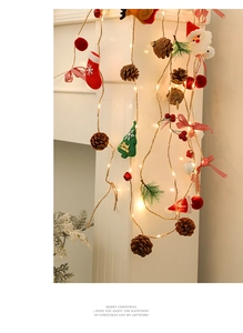 Detailed view of LED Christmas string lights with pine cones and plush ornaments
