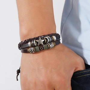 Detail of multi-layer leather bracelet with star charm and vintage beaded textures