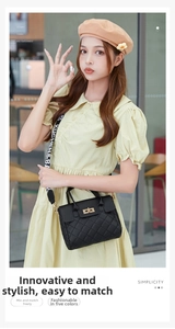 Close-up of black quilted handbag with gold buckle and fashionable wide shoulder strap
