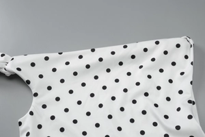 Detail of black and white polka dot print on premium stretch fabric of a summer dress