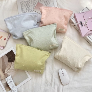 Detailed top view of five floral cotton toiletry bags in pastel colors with polka dot texture