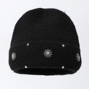 Close-up of black knit beanie featuring silver snowflake metal charms and small rhinestones