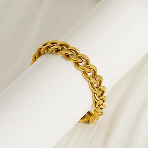 Chunky 18k gold plated stainless steel Cuban link bracelet on a white display stand
